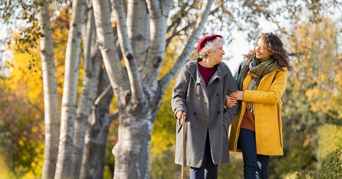 2 women walking, holding each other