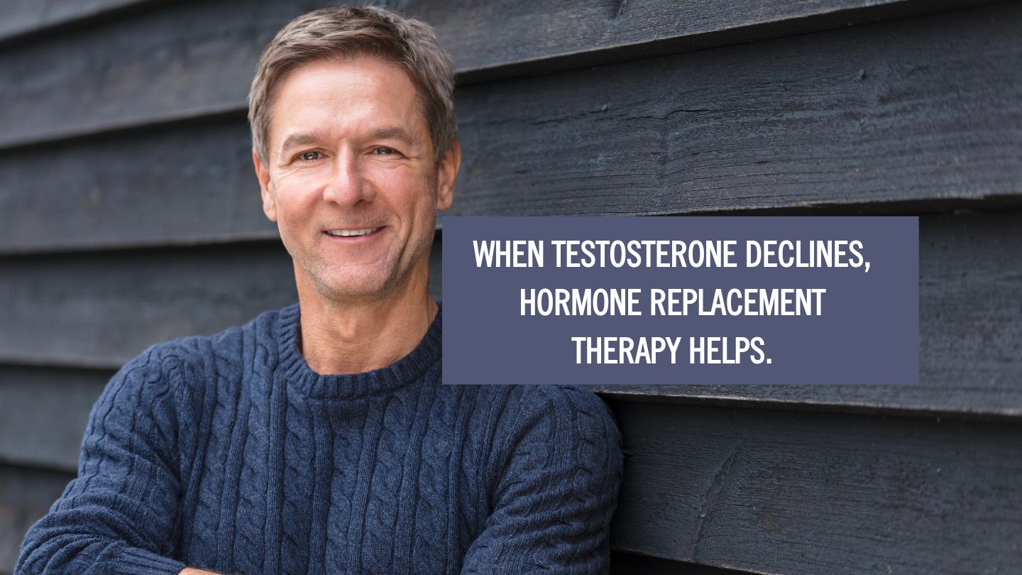 man in a blue sweater smiling with an overlay text saying "when testosterone declines, hormone therapy helps".